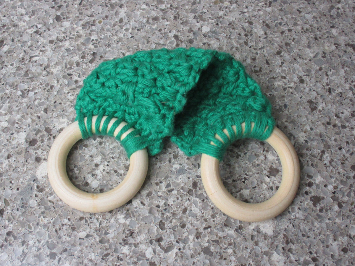 A handmade Kitchen towel Holder made of 100% Cotton Yarn in Bright  Green Color with two cream-colored wooden rings, shown on a speckled gray countertop.