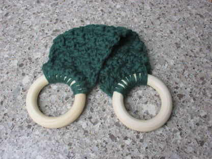A handmade Kitchen towel Holder made of 100% Cotton Yarn in Forest Green Color with two cream-colored wooden rings, shown on a speckled gray countertop.