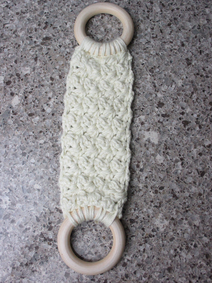 A handmade Kitchen towel Holder made of 100% Cotton Yarn in Ivory Color with two cream-colored wooden rings, shown on a speckled gray countertop.