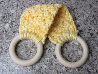 A handmade Kitchen towel Holder made of 100% Cotton Yarn in Yellow and Lt. Yellow Colors with two cream-colored wooden rings, shown on a speckled gray countertop.