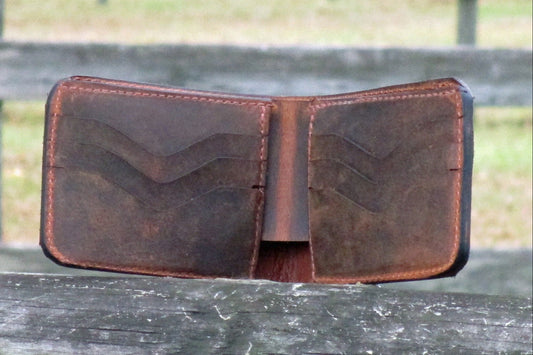 Crazy Horse Brown leather wallet on a wooden surface with a blurred natural background
